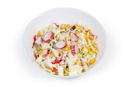 Salad of chopped crab sticks with napa cabbage, sweet corn, greens and mayonnaise dressing in white bowl on a white background
の写真素材