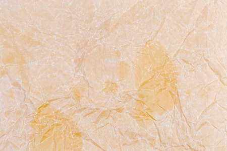 Fragment of sheet of yellow crumpled and then smoothed parchment paper close-up, texture, backgroundの写真素材