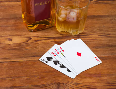 Combination of playing cards diamonds and spades suits laid out face up on the old rustic table...