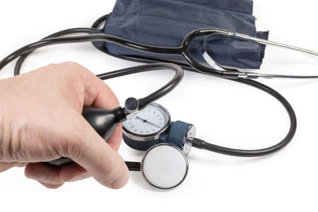 Rubber bulb of the manual aneroid sphygmomanometer in men's hand against the rest of the same device...