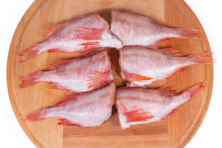 Raw headless gutted carcasses of redfish also known as ocean perch or Norway haddock on the round...