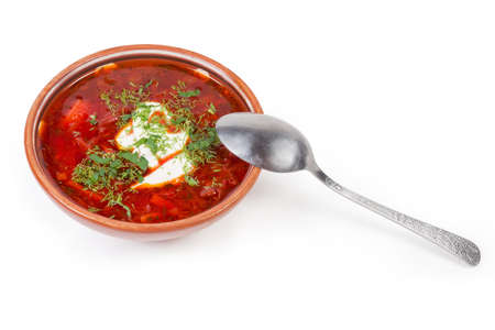 Typical red beetroot Ukrainian borscht seasoned with sour cream and sprinkled with fresh chopped...