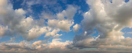Part of the sky with cumulus clouds in summer evening time before sunset, panoramic view