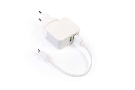 AC adaptor for mobile equipment batteries charging with two output ports and connected cable with USB-A and USB-C connectors on a white backgroundの写真素材