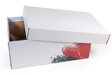 Empty white cardboard shoes box with slightly open lid and wrapping paper inside on a white...