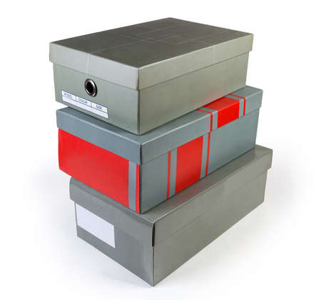 Different closed gray cardboard shoe boxes stacked on a white background