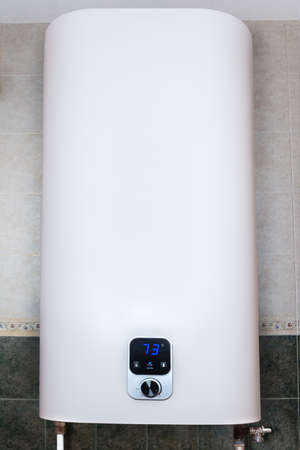 Household electric tank-type water heater, so called storage water heater hanging on the tiled wall verticallyの写真素材