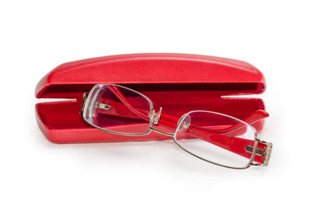 Modern eyeglasses for women in metal yellow rim with red plastic earpieces against the partly open red hard spectacle-case on a white background, close-up in selective focusの写真素材