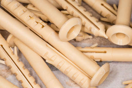 Pile of yellow plastic split-ribbed anchors, close-up in selective focusの写真素材