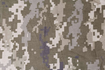 Fragment of slightly crumpled fabric with pixellated digital camouflage pattern dull olive-green and gray color close-up. Background, textureの写真素材