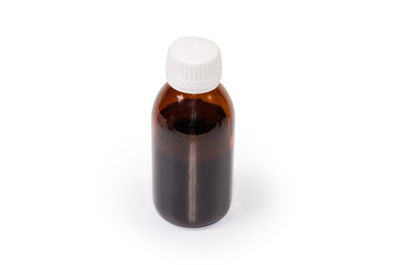 Closed small brown plastic bottle with liquid medicine on a white backgroundの写真素材