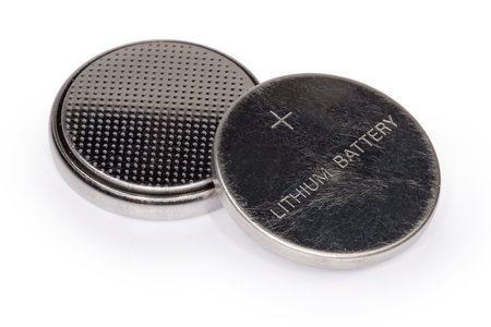 Two lithium button batteries on a white background, close-up in selective focusの写真素材