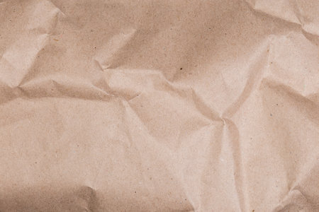 Fragment of sheet of gray brown slightly crumpled wrapping kraft paper close-up, texture, background
