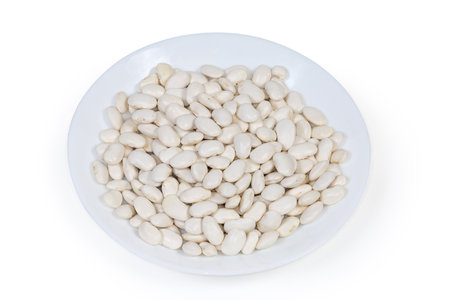 Raw dried large white kidney beans on a white dish on a white backgroundの写真素材