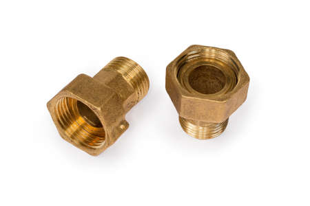 Two brass threaded plumbing connecting pipes with appropriate nuts on a white backgroundの写真素材