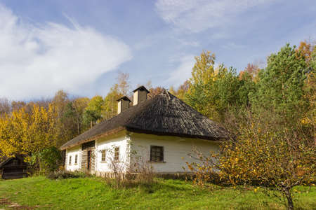 Old Ukrainian wooden farmhouse with thatched roof built in the 19th century, autumn day. Pyrohiv, Kyiv, Ukraineの写真素材