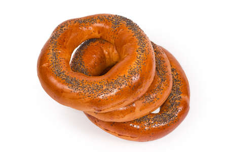 Stack of traditional Eastern European ring-shaped bread rolls sprinkled with poppy seeds before...
