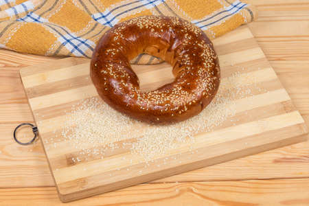 Traditional Eastern European ring shaped bread roll sprinkled with sesame  before being baked lies...