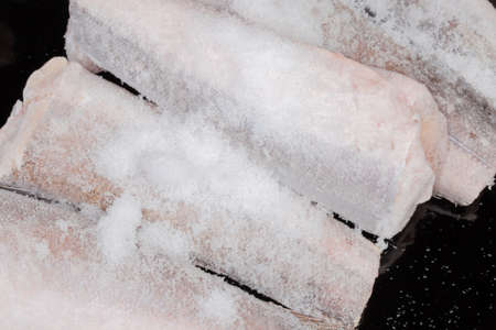Uncooked frozen carcasses of Argentine hake, or hake hubbsi without the heads and tails covered with hoarfrost, fragment top view close-upの写真素材