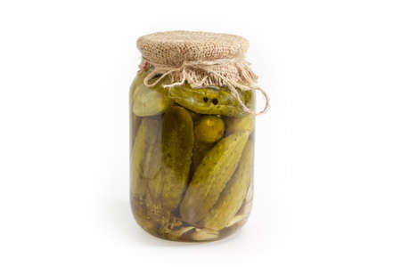 Canned cucumbers with spices in glass jar on a white backgroundの写真素材