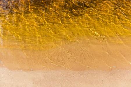 Section of shoreline of the reservoir sandy shore with calm water, top viewの写真素材
