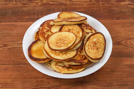 Pile of freshly fried small thick pancakes, in Eastern European cuisines so-called oladky or oladyi...