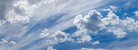 Sky with cirrus and cumulus clouds and flying birds silhouettes at summer day, panoramic view
