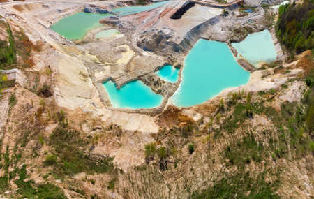 Small lakes with turquoise water in china clay quarry in summer day, aerial view