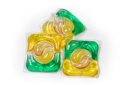 Colored laundry detergent capsules on a white background, top view