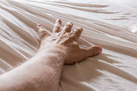 Left hand of adult man outstretched forward away from yourself with spread all fingers lies with...