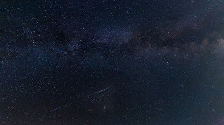 Fragment of night sky with Milky Way section, many stars and several meteor trails