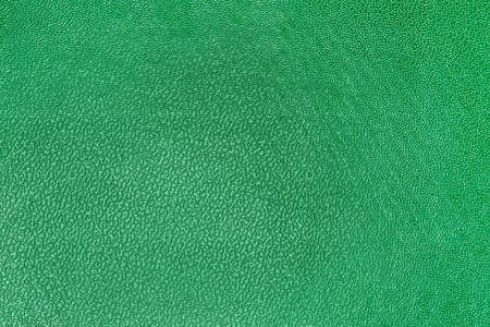 Texture of imitation leather dyed in green, fragment of the leather product close-up, backgroundの写真素材