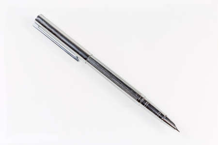 Modern metal fountain pen with open split nib and pen cap put on the top on a light surfaceの写真素材
