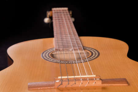 Part of the old traditional wooden acoustic guitar with six strings, view of soundboard close-up in...