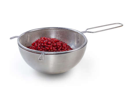 Washed berries of the ripe redcurrant in the metal sieve on the bowl made with stainless steel on a white backgroundの写真素材
