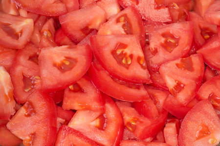 Slices of the fresh red tomatoes cut for salad preparation, top view close-upの写真素材