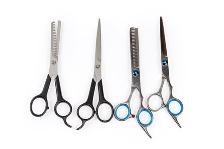 Several pairs of professional stainless steel normal hairdressers scissors and hair thinning scissor, top view on a white backgroundの写真素材