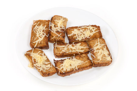 Hot open sandwiches made with small slices of brown grain bread and grated melted cheese on the...