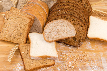 Sliced dark brown bread made from rye and wheat flour, bread with bran, untoasted white and whole...