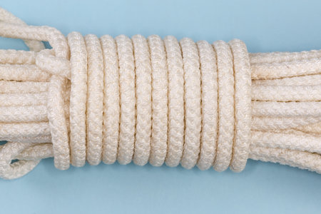 Bight of the accessory cord tied with Alpine coil knot, fragment of the bight close-up on a blue...
