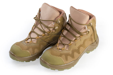 Pair of the green-beige waterproofed summer combat boots on shoelaces on a white backgroundの写真素材