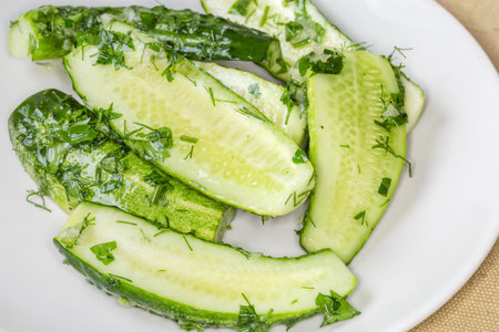 Semi-pickled, or lightly salted cucumber halves made with short-term salting method on a dish, close-up in selective focusの写真素材