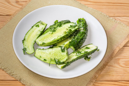 Semi-pickled, or lightly salted cucumber halves made with short-term salting method on a dish on a place matの写真素材