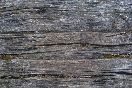 Texture of the old dark wooden planks as a covering of the narrow footbridge, top view in overcast weatherの写真素材