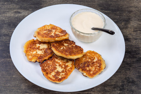 Cottage cheese pancakes with sour cream on the dishの写真素材