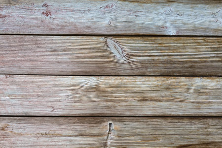 Old wooden shield made with the horizontally located roughly handled planks with knots, textureの写真素材