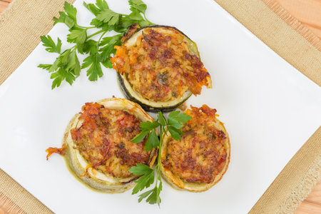Cooked pieces of zucchini stuffed with filling of the boiled rice with minced meat on the square dish, top view close-upの写真素材