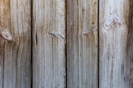 Texture of the old wooden shield made with vertically located roughly handled planks with knots, backgroundの写真素材