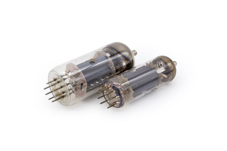 Two different old electronic vacuum tubes with top caps connections for higher voltages on the anodes are lie on a white backgroundの写真素材