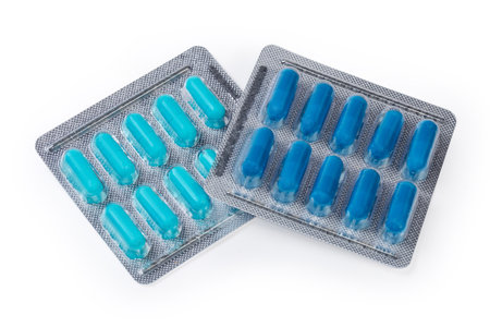 Different blue pills in the two blister packs on a white backgroundの写真素材
